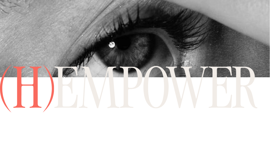 Un primer plano de un ojo en blanco y negro, parcialmente cubierto por la palabra (H)EMPOWER con (H) en rojo y EMPOWER en un tipo de letra grande y pálido a través de la imagen.