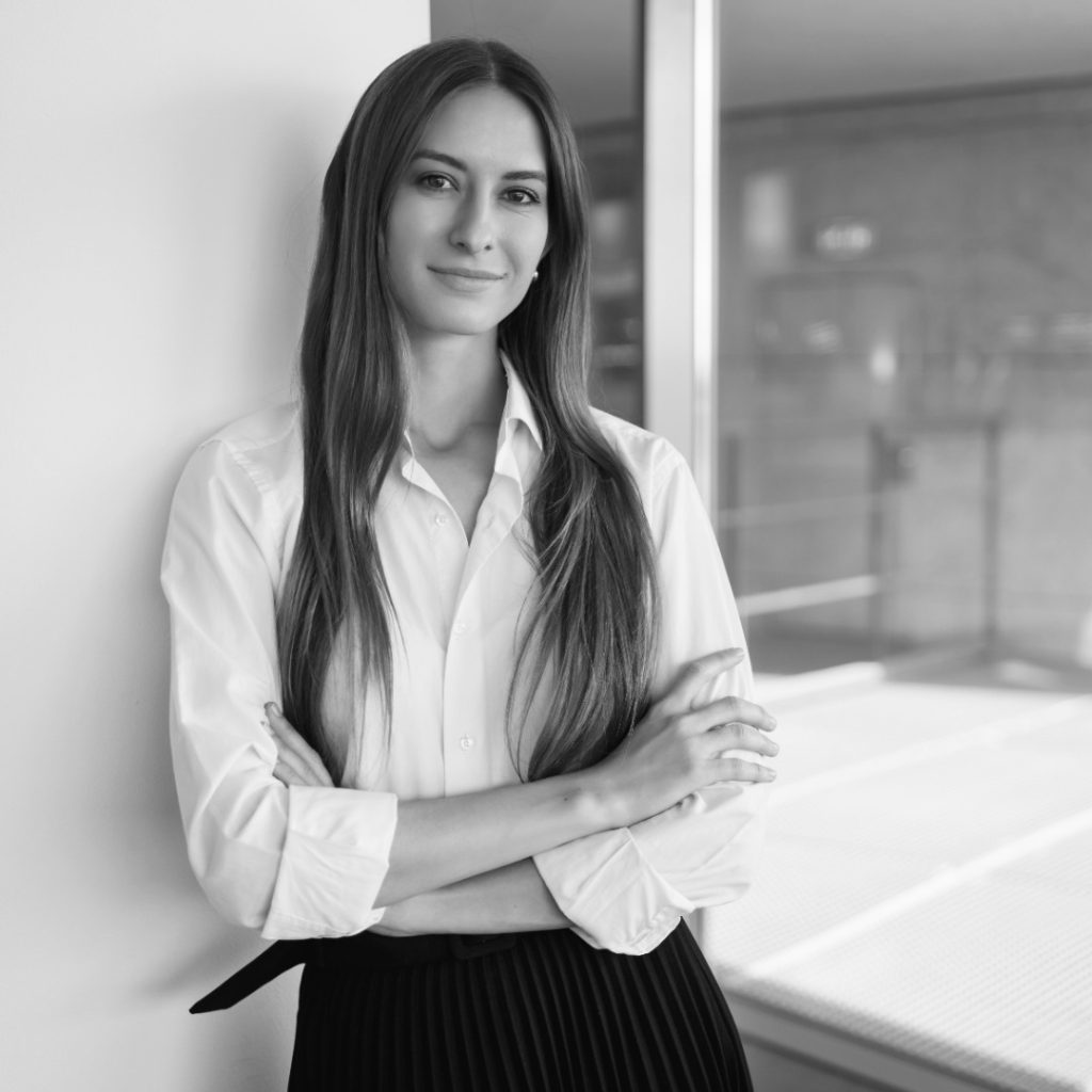 atractiva empresaria joven satisfecha de pie orgullosa sonriendo con las manos cruzadas confiado photoaidcom greyscale 1080x1080 (1)