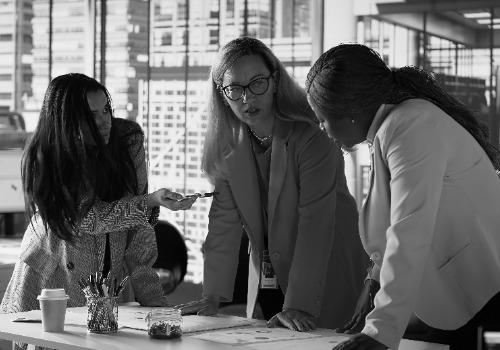 director general revisando el analisis de datos con el equipo para un desarrollo exitoso photoaidcom greyscale 500x350