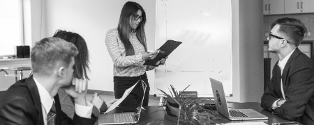 joven empresaria mirando el documento en la reunion de la junta photoaidcom greyscale (1) 450x180