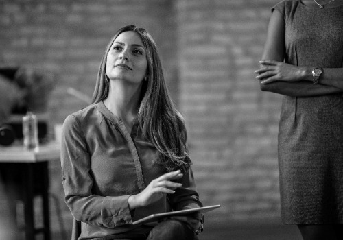 joven empresaria sosteniendo touchpad mientras escucha la presentacion en la oficina photoaidcom greyscale 500x350