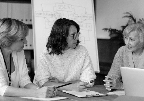 mujeres de negocios discutiendo en la mesa photoaidcom greyscale 500x352