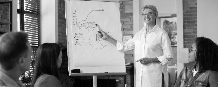 persona que presenta informacion para la reunion en la pizarra photoaidcom greyscale 450x180